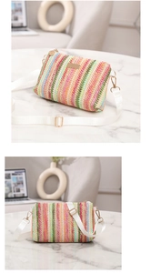 Détail du sac enveloppe en paille tressée arc-en-ciel avec bandoulière et décorations dorées