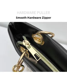 Makro-Detail des glatten goldenen Reißverschluss-Schiebers an einer schwarzen Tasche