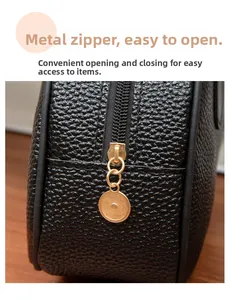 Detail of high-quality metal zipper and lychee leather texture on black handbag