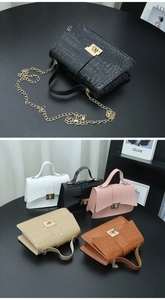 Detail showing various colors of crocodile pattern handbags with gold chain straps