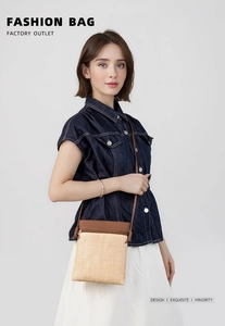 Detail showing the straw woven texture and brown leather flap of the stylish crossbody bag