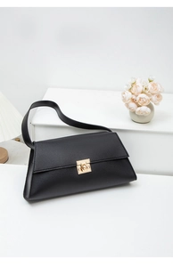 Détail du sac bandoulière en cuir mat noir avec un fermoir rotatif carré doré élégant