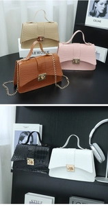 Detail of crocodile pattern handbags in five colors with golden chains and handles