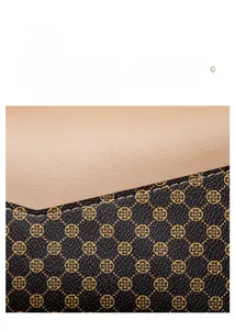Close-up of beige leather and brown clover print fabric stitching on a crossbody bag