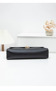 Détail du sac baguette en cuir grainé noir avec fermoir rotatif en métal doré chic