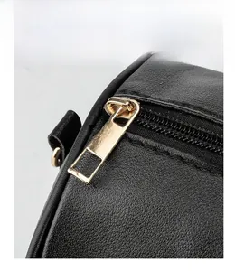 Detailansicht des glatten goldenen Metallreißverschlusses an einer schwarzen Ledertasche