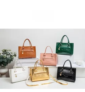 Vielfalt an Handtaschen mit Krokodilmuster, Metallkettenriemen und runden Logo-Anhängern