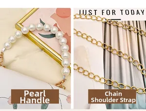 Close-up of white leather bag with pearl handle, floral embroidery and gold chain strap