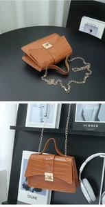 Detailed macro view of brown crocodile texture handbag with gold metal clasp and chain