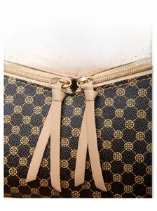 Detail of dual metal zippers and clover patterned leather on a dark brown handbag