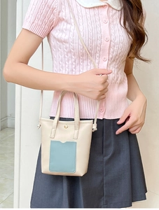 Détail du sac seau beige avec fente pour carte bleu clair et fermoir aimanté doré