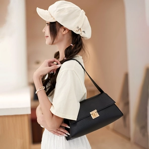 Sac baguette minimaliste en cuir noir avec élégant fermoir rotatif en métal doré