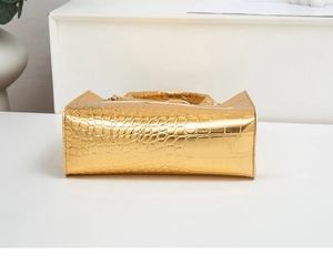 Detailansicht des rechteckigen Bodens mit feinen Nähten einer goldenen Krokodiltasche