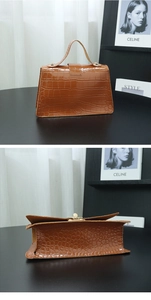 Detailed back view of brown crocodile texture handbag with trapezoidal structure and lock