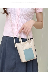 Détail d'un mini cabas en PU crème avec poche bleue et boucle magnétique dorée chic