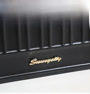 Makroansicht aus schwarzem geprägtem Leder und goldenem Summypretty-Metalllogo