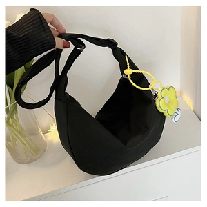 Détail du sac bandoulière demi-lune noir en nylon avec un charme fleur jaune