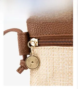 Detail of woven straw texture and premium brown lychee leather with golden zipper