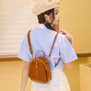 Chic caramel brown mini backpack in soft PU leather with golden pendant decoration