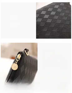 Detail of black woven texture and polished gold zipper on minimalist shoulder bag