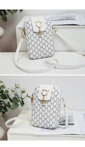 Detail of white mini crossbody phone bag with M-letter print and pearl cat-ear clasp