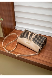 Detail view of the brown geometric pattern and beige leather on this stylish crossbody bag