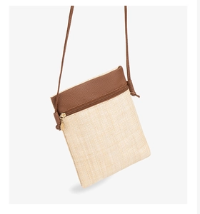 Close-up of woven straw texture and premium brown leather trim on a crossbody phone bag