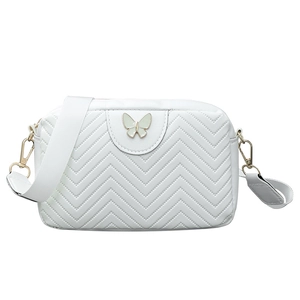 White wave-quilted camera crossbody bag featuring a green butterfly metal emblem