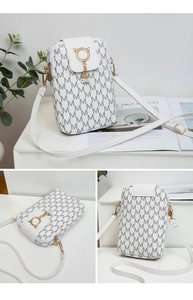 Detailed view of white monogram crossbody bag with pearl tassel and cat-ear metal ring