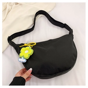 Détail du sac bandoulière noir en demi-lune avec breloque fleur jaune et sangle