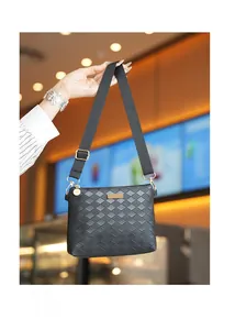 Detail of classic black woven pattern leather shoulder bag with shiny gold hardware