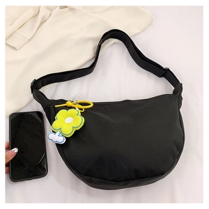 Détail du sac bandoulière demi-lune en nylon noir avec un charmant pendentif fleur jaune