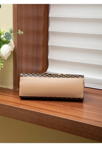 Close-up of the reinforced stitching and smooth leather base of a printed ladies handbag