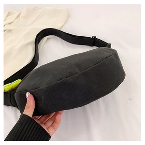 Vue détaillée du sac croissant en nylon noir avec bandoulière réglable et petit bijou