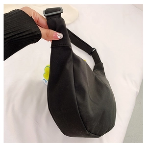 Gros plan détaillé d'un sac bandoulière en toile noire avec une bandoulière réglable