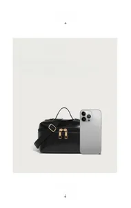 Detail of black oil wax leather handbag with double zippers and phone for scale