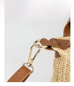 Detailaufnahme des goldenen Metallverschlusses und der Webstruktur der Strohtasche