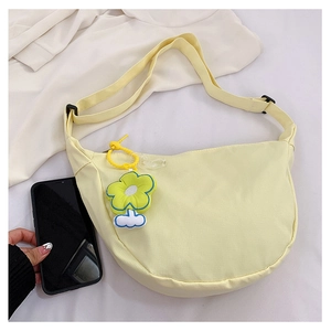 Détail du sac bandoulière croissant jaune clair avec breloque tournesol et sangle