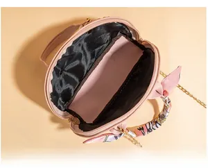Internal view of shell handbag showing spacious black lining and silk scarf handle detail
