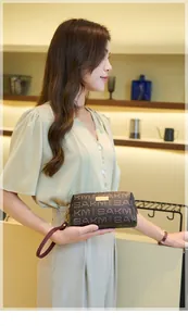 Detailed view of vintage brown monogram clutch bag with elegant wristlet and gold zipper