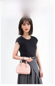 Model showing a pink quilted shell handbag with silk scarf detail on handles