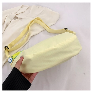 Détail du sac à bandoulière en nylon jaune clair avec accessoire nuage de dessin animé