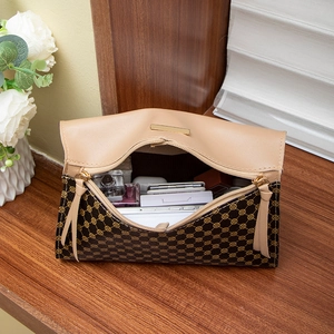 Women's vintage printed crossbody handbag with beige leather flap on wooden desk