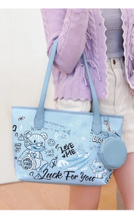 Détail du sac cabas bleu clair à motifs graffiti et sa petite pochette ronde assortie