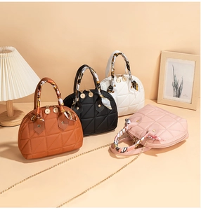 Detailed view of quilted shell handbags with silk scarf handles and chain straps