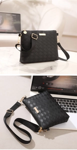 Detail of black quilted shoulder bag with gold hardware and adjustable strap