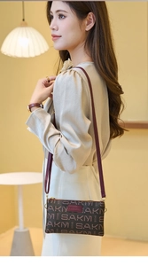 Detail showing the brown monogram synthetic leather texture and golden zipper of the bag