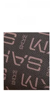 Macro detail of dark brown textured leather fabric with vintage monogram patterns