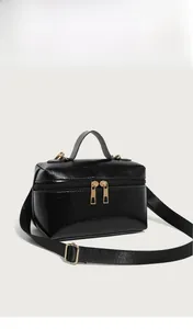 Detail of oil wax leather handbag with golden dual zippers and nylon shoulder strap