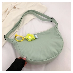 Détail du sac demi-lune en velours côtelé vert clair avec sangle et pendentif fleur